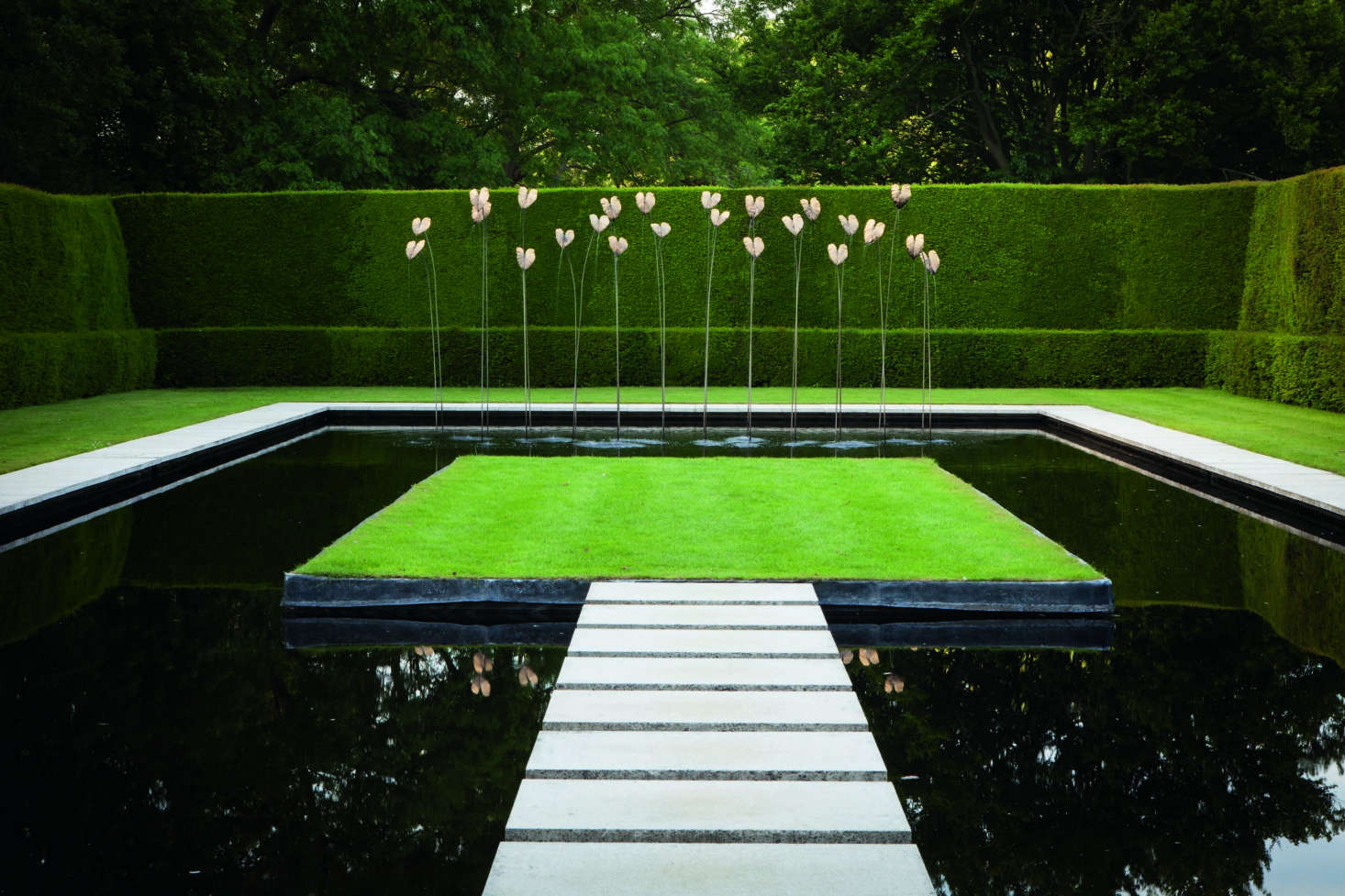 The cool black Water Garden was created by Anne Chambers on what was once a clay tennis court built by her grandmother Heather Muir. The design was inspired by Sir Geoffrey Jellicoe’s black lily pond at Sutton Place. The centerpiece is a swath of bronze philodendrons made by sculptor Simon Allison.