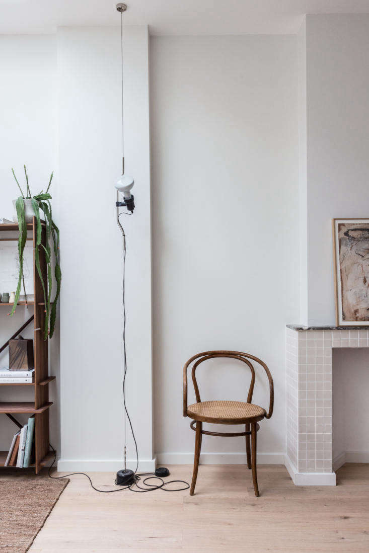 A vintage Thonet armchair sits pretty next to the very modern Parentesi Suspension Light. Photograph by Holly Marder, from Steal This Look: An Interior Designer’s High/Low Scandi Living Room, Ikea Sofa included.