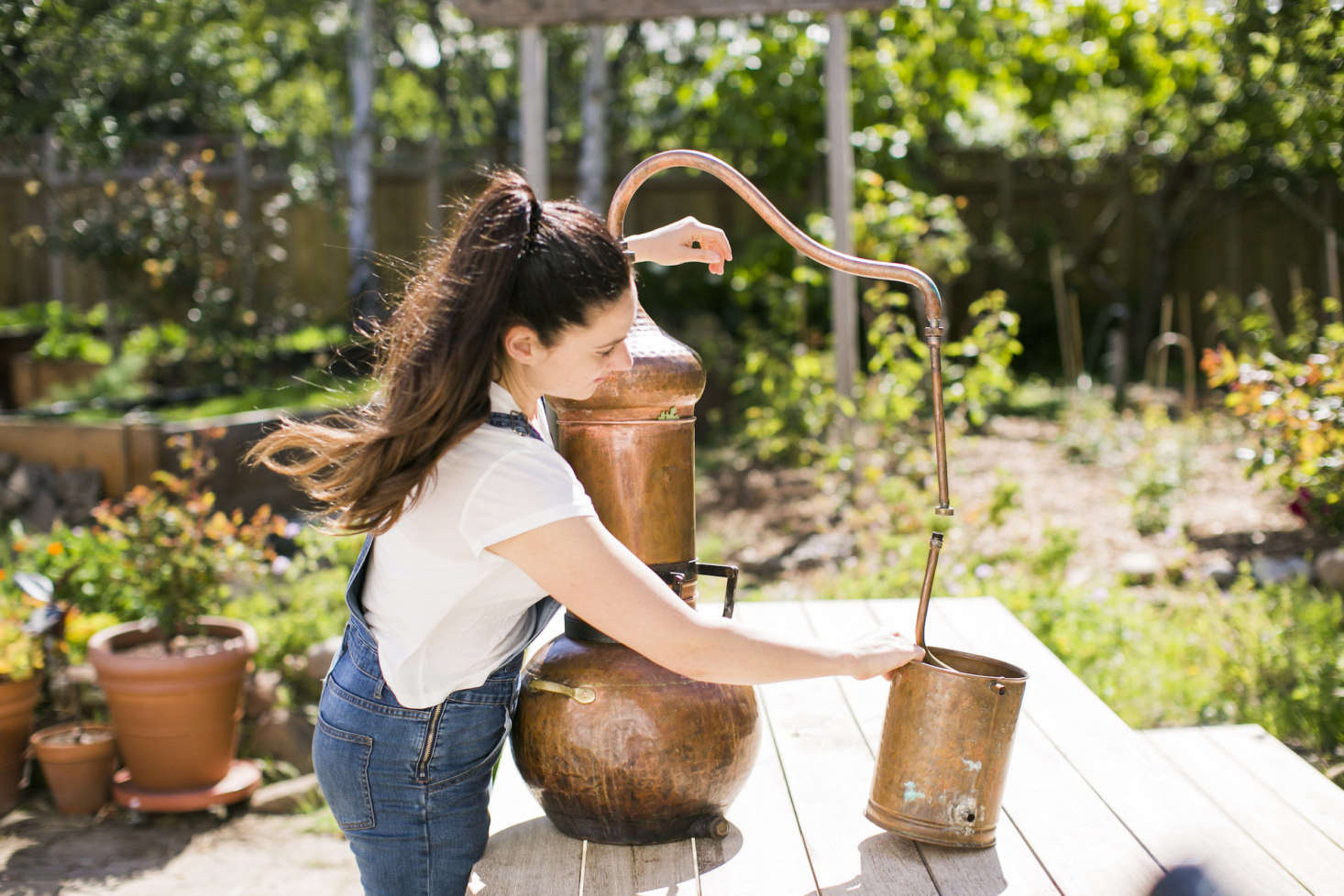 Justine with her functional and aesthetically pleasing copper still. She makes hydrosols or flower waters weekly in the summer months, using techniques dating back data-src=