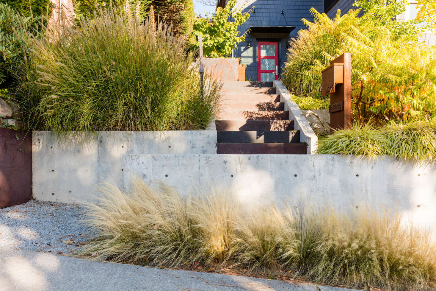 The house now has curb appeal thanks to new retaining walls and stairs. Billowing grasses greet visitors as they walk up the steps.