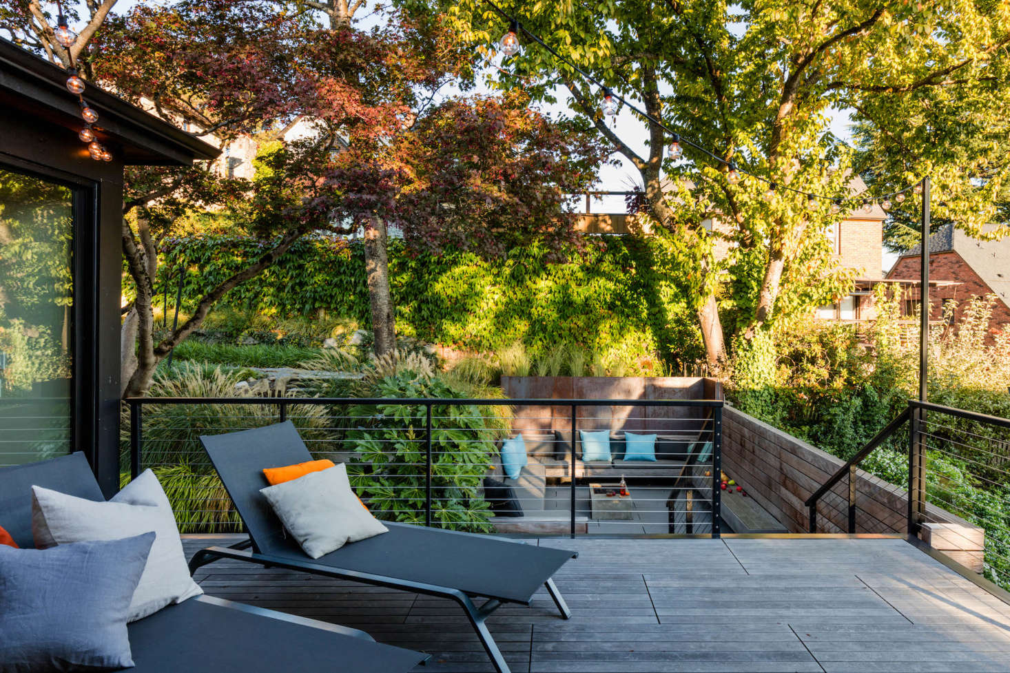 In the back of the house, the kitchen and dining area opens out onto an ipe hardwood deck that steps down to a larger outdoor living room below.