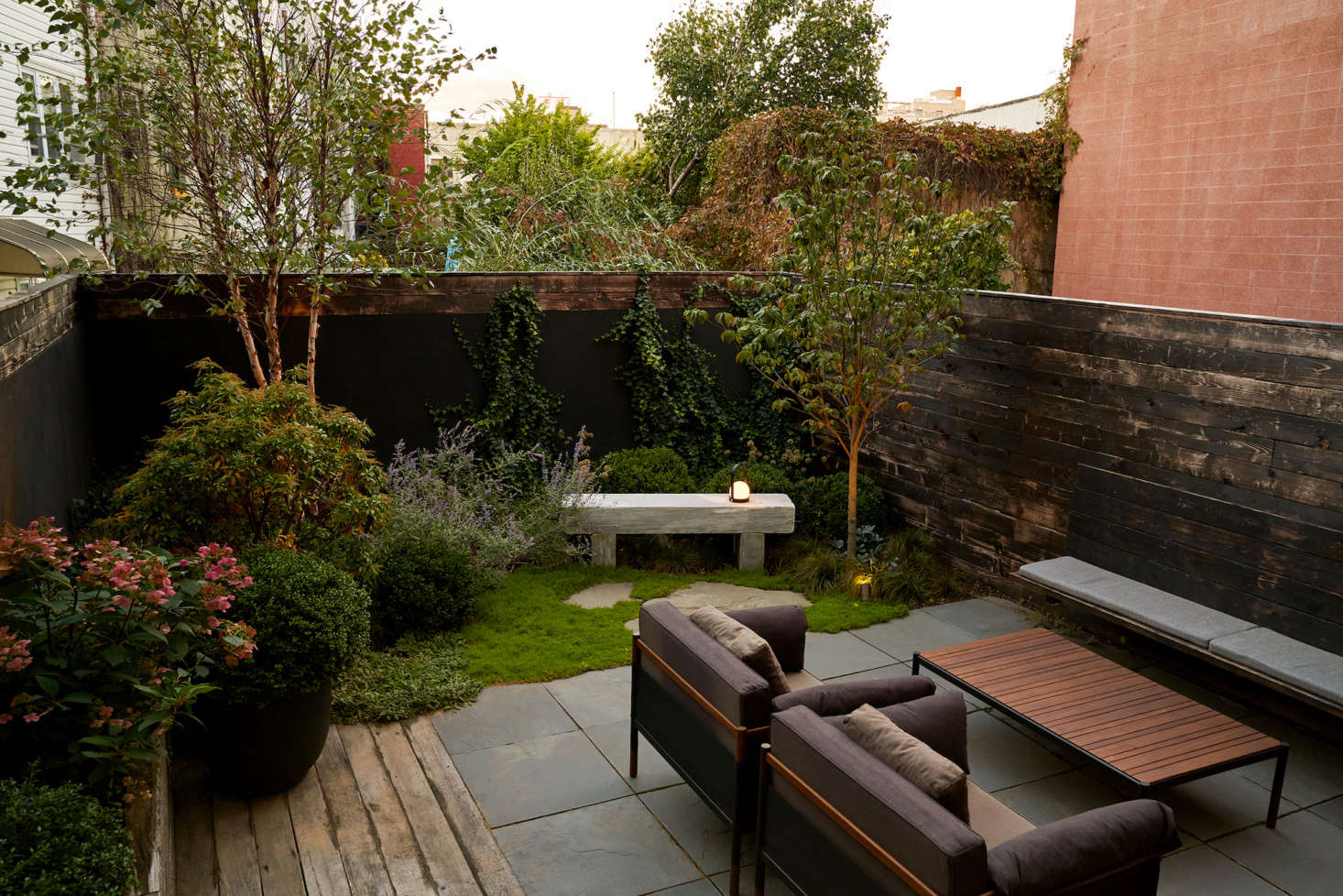 Brook wrapped the walls here with ipe wood salvaged from the Rockaways boardwalk after Hurricane Sandy. A mix of the same wood and cleft bluestone tiles form the patio. 
