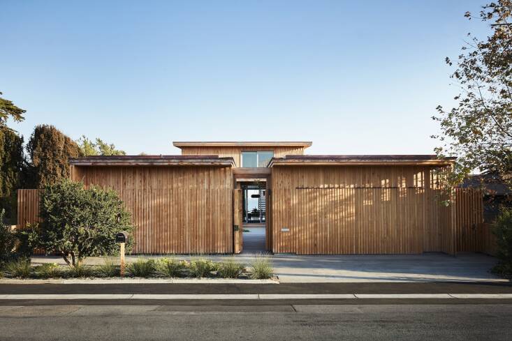 The almost-hidden garage on the right blends seamlessly with the exterior of the home, clad in salvaged Monterey cypress that was sourced by wood whisperer Evan Shively of Arborica. The wood is meant to turn gray over time and is quite resilient in the coastal climate.