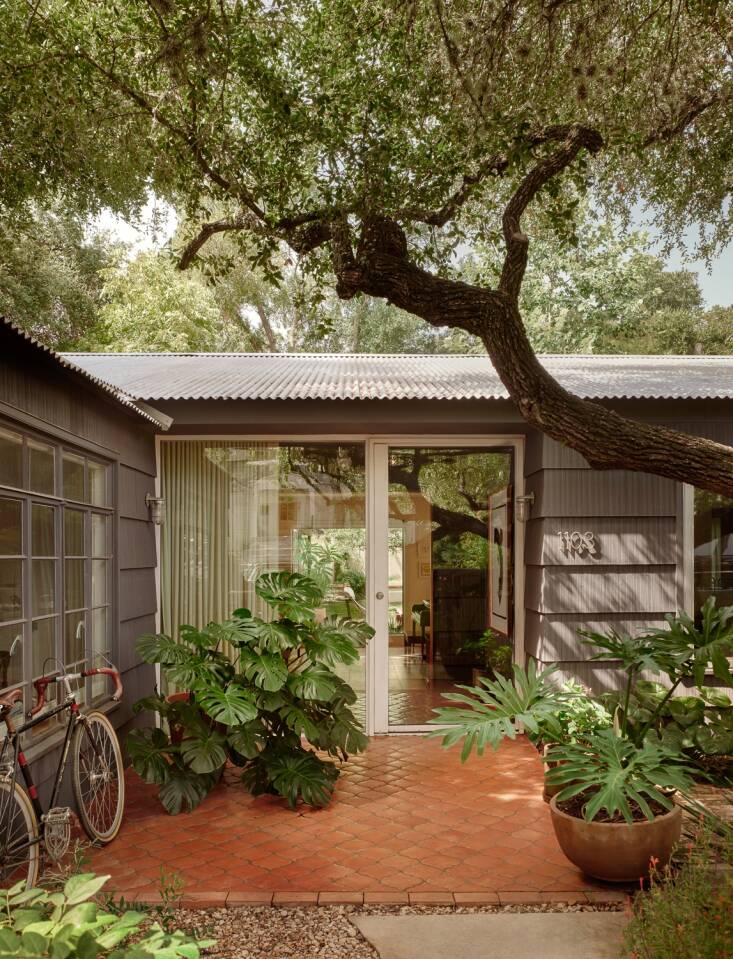 An all-glass front door hints at the couple\2\17;s desire to blur the line between indoors and outdoors. The Saltillo terracotta tiles (from Clay Imports) continue into the foyer inside.