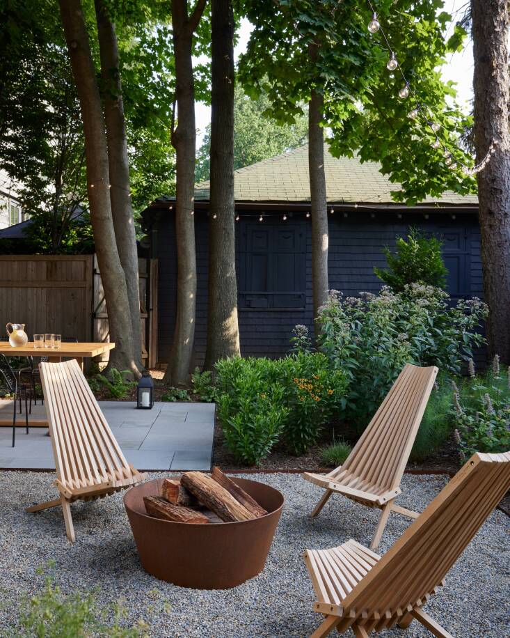 Repeated materials give the garden a pulled-together look, especially in a smaller space. For example, the garden bed edging is the same Cor-ten steel as the firepit, and the chairs around it are teak like the dining table. 