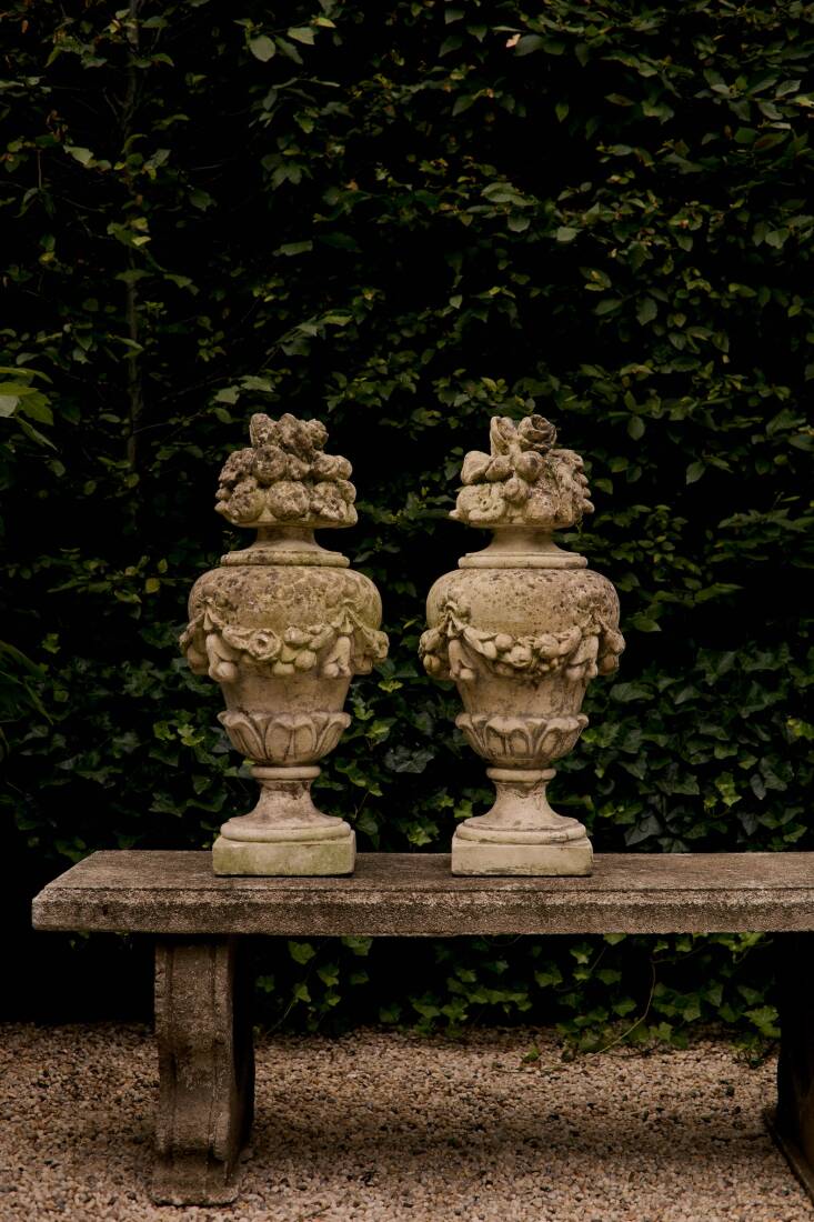 A pair of French Cast Stone Cornucopia Finials from the \1950s &#8\2\20;equally suited to flank an entryway, anchor a garden path, or bring architectural presence to a serene, verdant space,&#8\2\2\1; write the Harrisons. The \19th-century Cast Stone Heart-Leg Bench has hearts inlaid in its base.