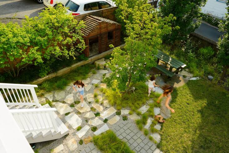 Lu — La Design relied on texture and materials to “define spaces and create a flow between them.” Reclaimed granite pavers appear on the front walkway, the ribbon driveway, and the threshold between the side and back yards, while irregular flagstone offer contrast in other areas.