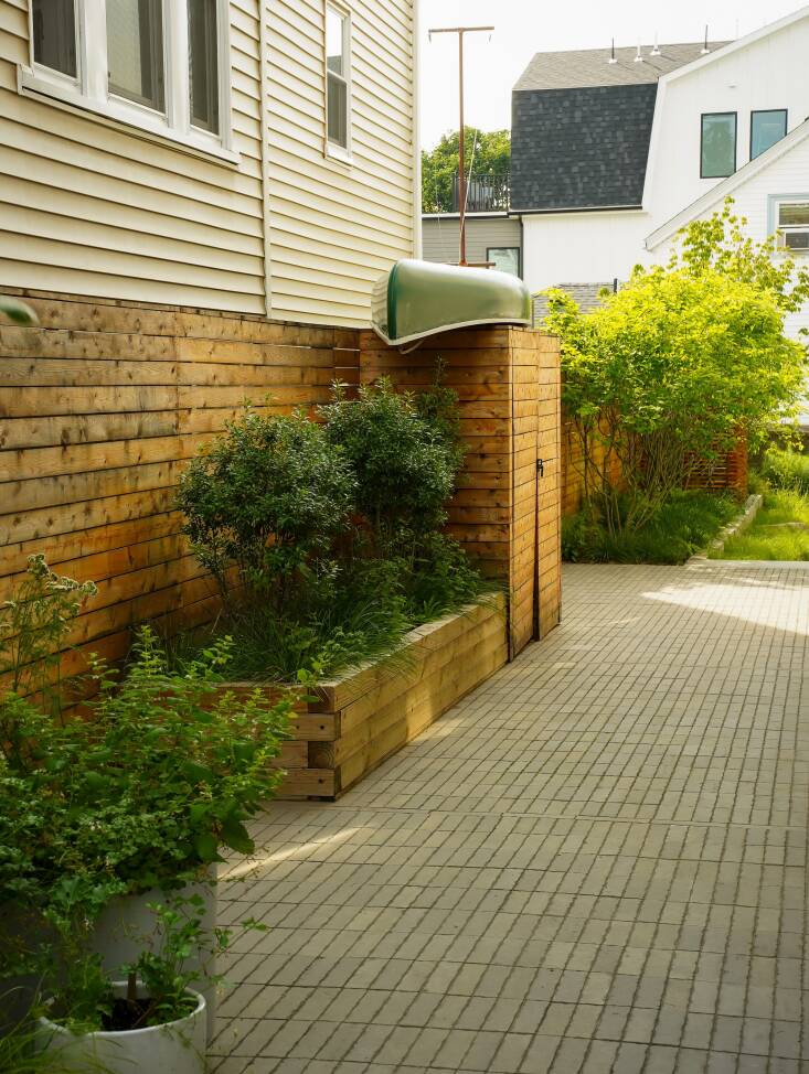 The side yard is the only space with true hardscape, because so much water passes by during rain events. The concrete blocks are pitched down at \2-percent toward the backyard, where the water hits the rock mulch and percolates into the ground. Residents park their bikes here in the summer.