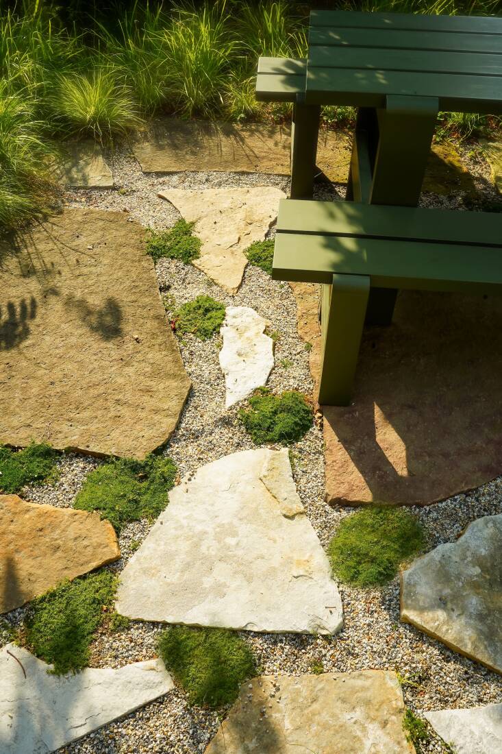 The flagstone, including three extra large pieces of petrified sea bed under the picnic table, came from a local stone yard. The rock mulch has warm and cool tones that marries all the stones together.