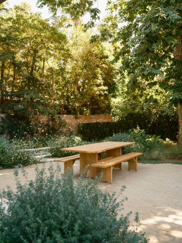 A view of the new patio for al fresco dining, whose curvilinear forms and hazy planting blur the lines between the different areas. Just beyond is the pool.
