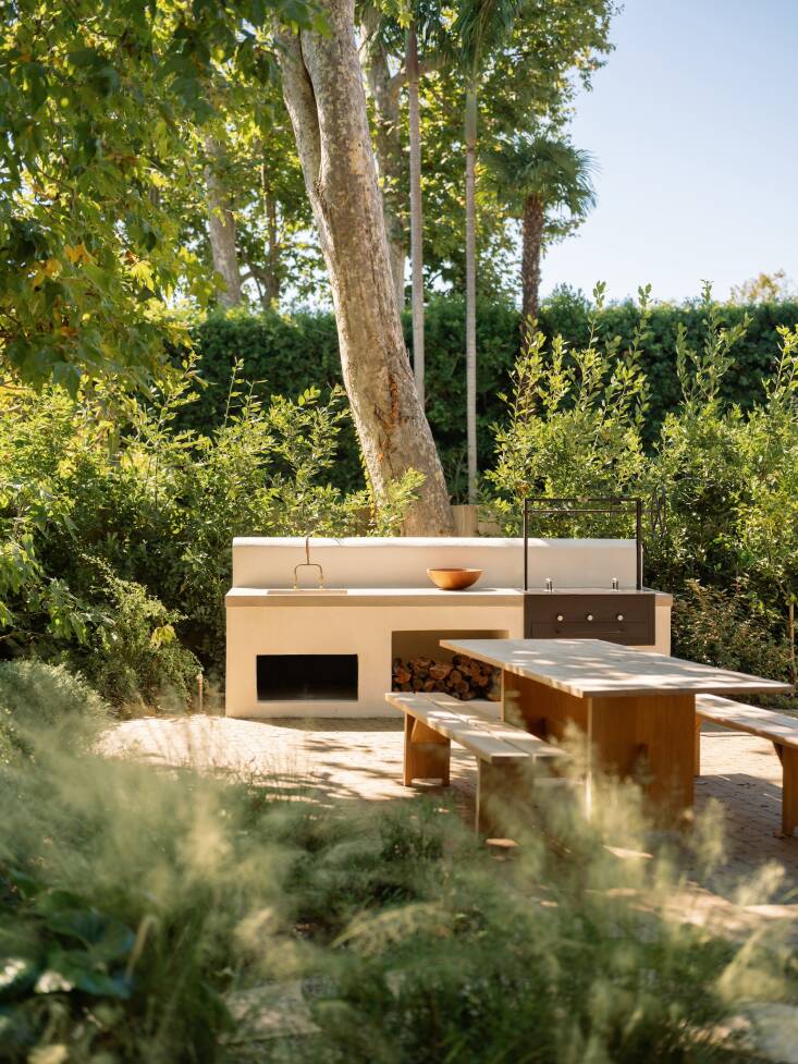 The rear of the property features a new outdoor kitchen with integrated firewood storage in a stucco finish that melds with the home’s existing architecture.