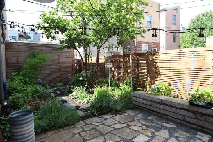 For this garden in the Fishtown neighborhood of Philadelphia, Apiary Studio made use of locally-sourced and recycled materials, including pieces of the old parking slab upcycled as pavers and a wall seat, which are softened by dense plantings. Photograph by Jaime Alvarez, courtesy of Apiary Studio.