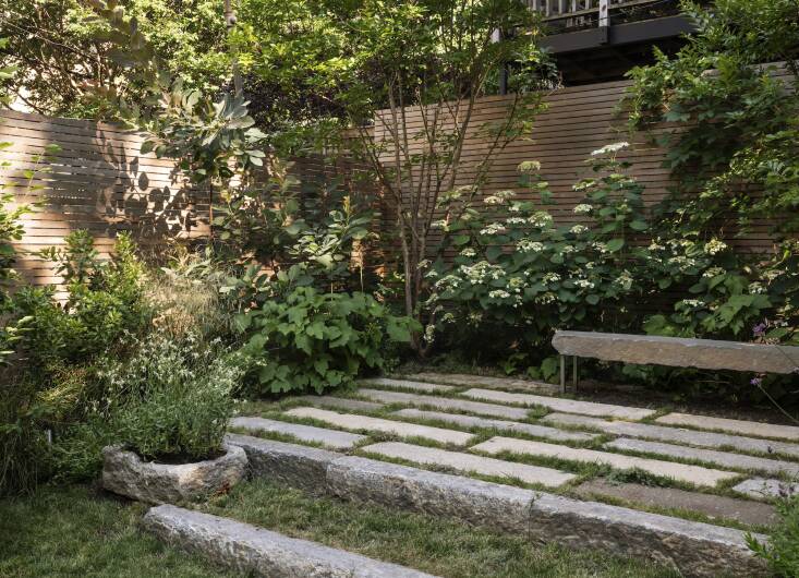 Reclaimed stone planks aligned with Farris’s clients’ desire for sustainable materials and also instantly made the garden feel more established. The furthest back section of the yard had dirt piled up post-construction, so Farris had her contractors terrace it. Upcycled granite curbs hold the higher level. 