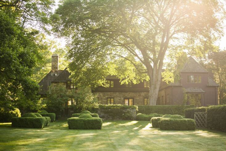 Early morning light streams through the house and out over the western façade. Boxwoods shaped into domed squares echo the axis from the house to the landscape. An Ulmus americana towers over the house and provides shade from the sometimes intense late-afternoon sun. Photograph by Neil Landino, from A Moment in Time.