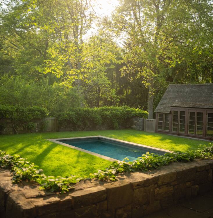 “A low stone wall surrounds the pool garden, keeping it from feeling too exposed while allowing views out and across to other areas of the property—and up to the tree canopy,” writes Herman. Photograph by Neil LandinoGarden Visit: Classic English Garden Style at Hollister House in Connecticut, from A Moment in Time.