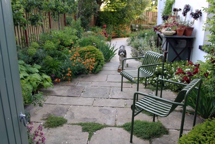 Note how Morton cleverly concealed an external oil boiler (at right) that dominated the view along this arm of the garden. Morton designed what he calls a \2\20;collector’s table,” a reclaimed slate table top with custom-made corten legs, to hold the clients\2\17; potted sun-loving plants.