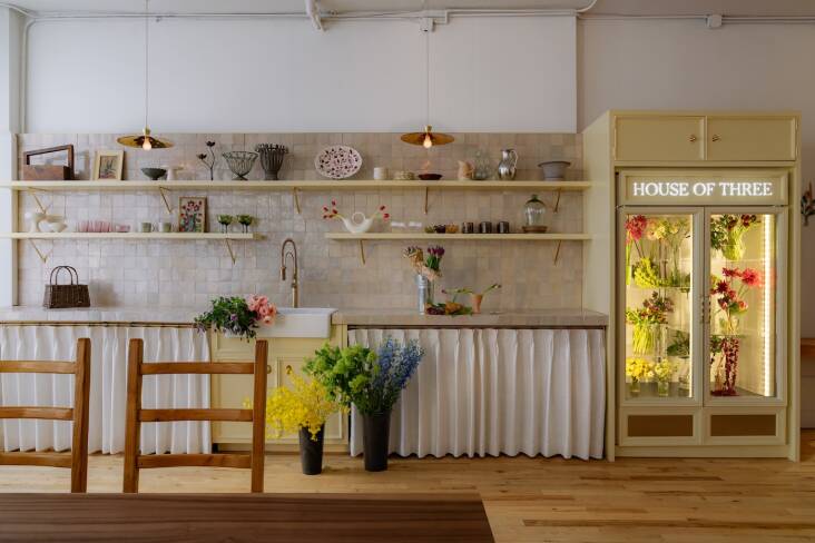 House of Three \2\16;s showpiece is its \2\20;florist\2\17;s kitchen,\2\2\1; complete with a potting sink, classic flower fridge, and plenty of storage—but no stove. The brass knobs and Floral Brass Pendant lights are from British designer Matilda Goad\2\17;s MG & Co.