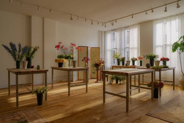 Raise-and-lower butcher-block-topped steel work tables from Global Industrial can be grouped in various ways for parties and workshops. The wooden flooring and track lighting came with the space—they\2\17;re holdovers from its lighting showroom days.