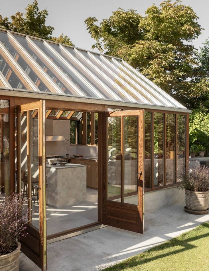 French doors welcome guests into the one-room orangery, which has walls of cedar and glass on all four sides in addition to a glass roof.