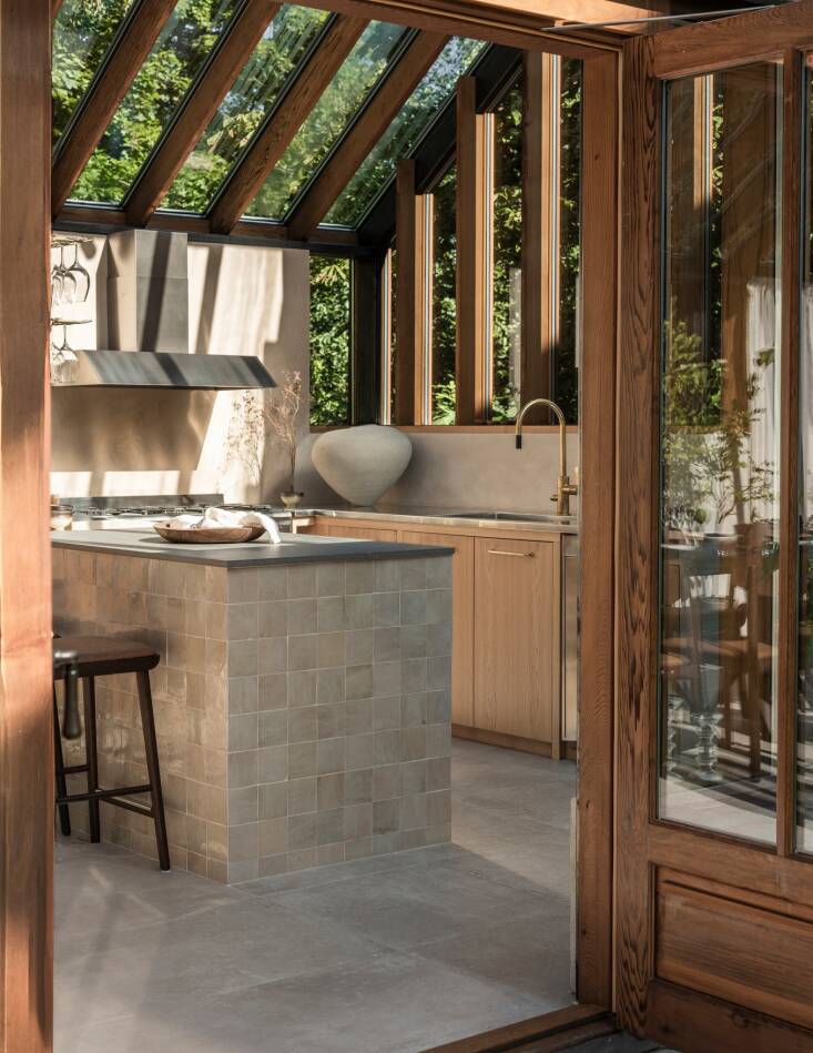 On one end of the room is a small U-shaped kitchen. Handmade French tiles cover the peninsula.