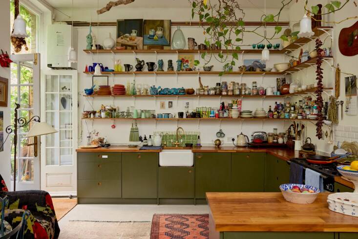 The olive-green kitchen is by Naked Kitchens. The French doors at left lead to a private garden.